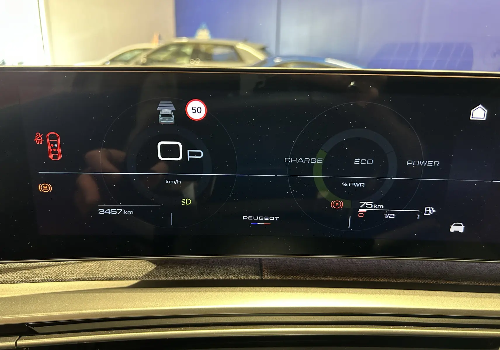 Affichage numérique du tableau de bord du Peugeot 3008 blanc, montrant la vitesse, autonomie et indicateurs de conduite.