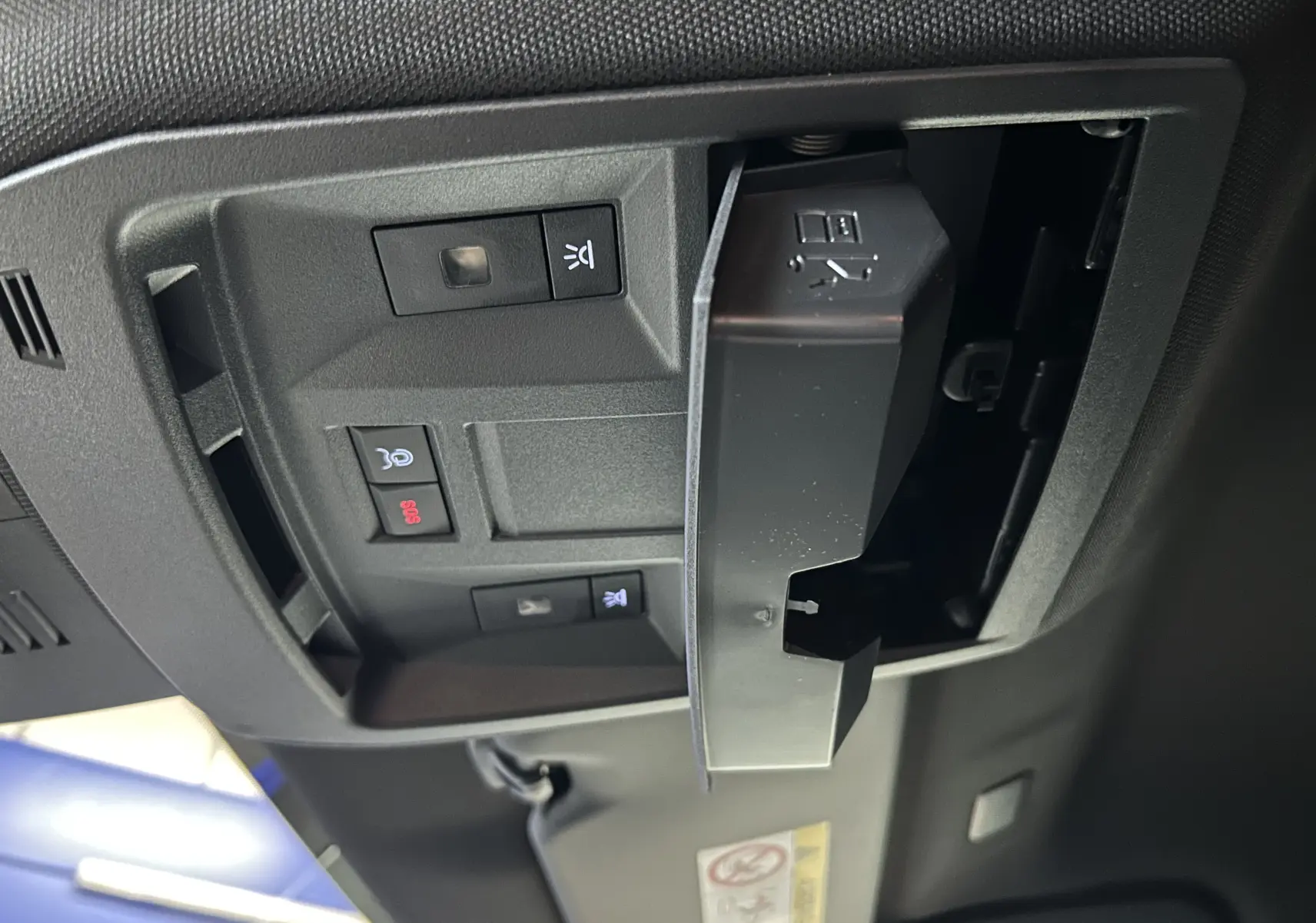 Vue en gros plan du panneau de commandes au plafond du Peugeot 3008 blanc, avec bouton SOS et éclairage intérieur.