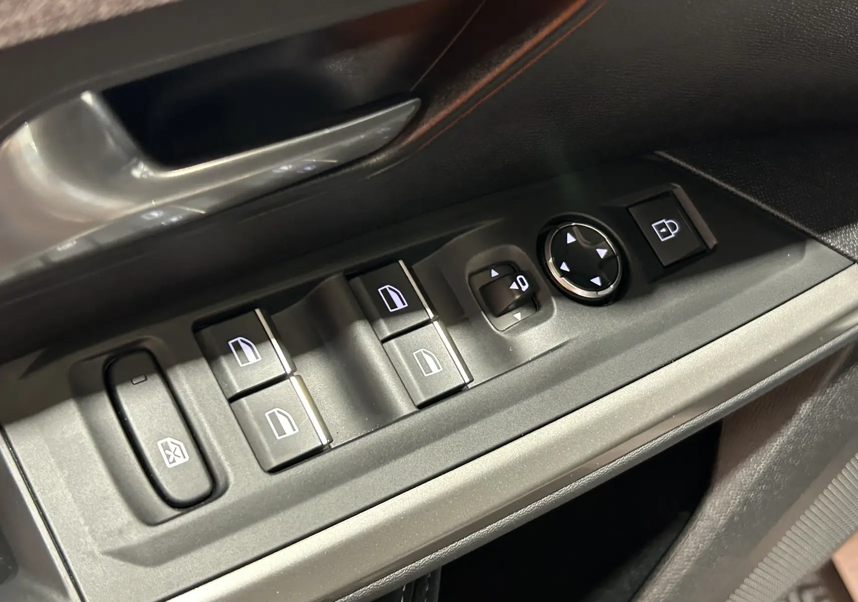 Gros plan sur les commandes des vitres et rétroviseurs côté conducteur de la Peugeot 3008 III Hybrid 145 en intérieur noir.