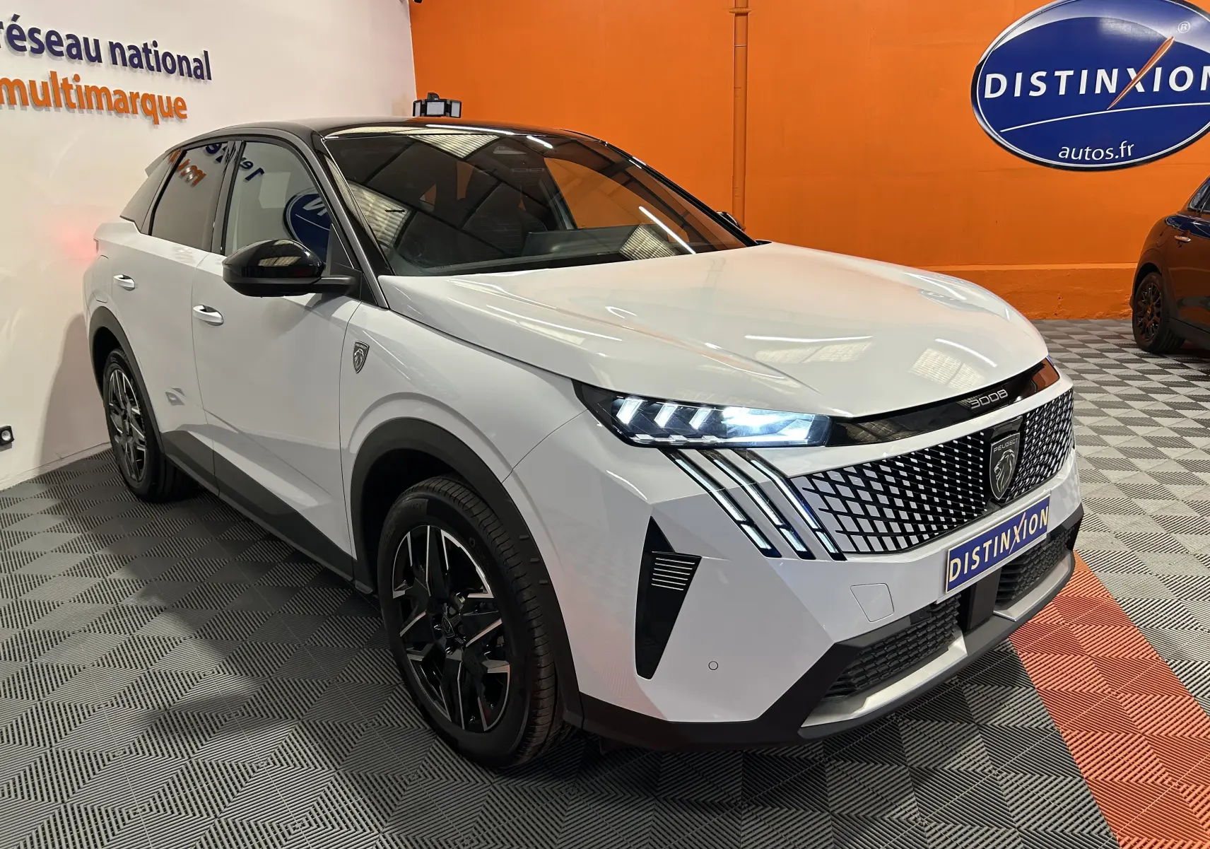 Peugeot 3008 III Hybrid blanc Okenite en 3/4 avant droit, avec calandre distinctive et phares LED allumés.