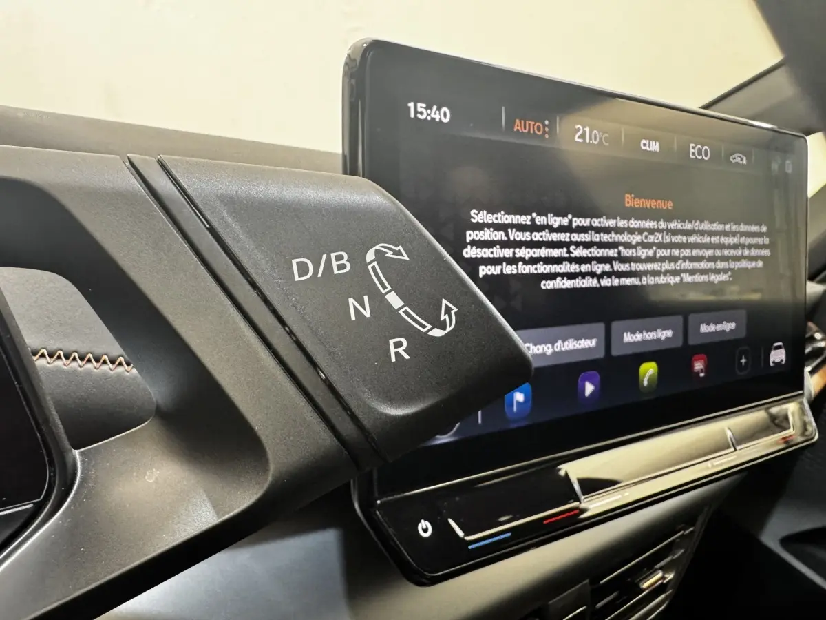 Gros plan sur la commande de boîte automatique et l'écran tactile central affichant les réglages climatiques du CUPRA Born gris foncé.