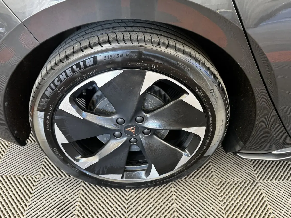 Gros plan sur la roue avant droite d'une CUPRA BORN gris foncé avec jante noire et argentée au design moderne.