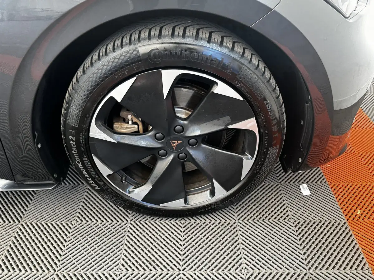 Gros plan sur la roue avant gauche gris foncé d'une CUPRA BORN 230ch, jante noire et argentée distinctive.