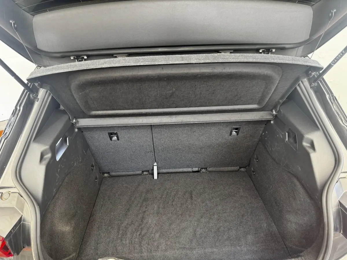 Coffre ouvert vu de l'arrière d'une CUPRA Born gris foncé, montrant l'espace de chargement et la tablette cache-bagages.