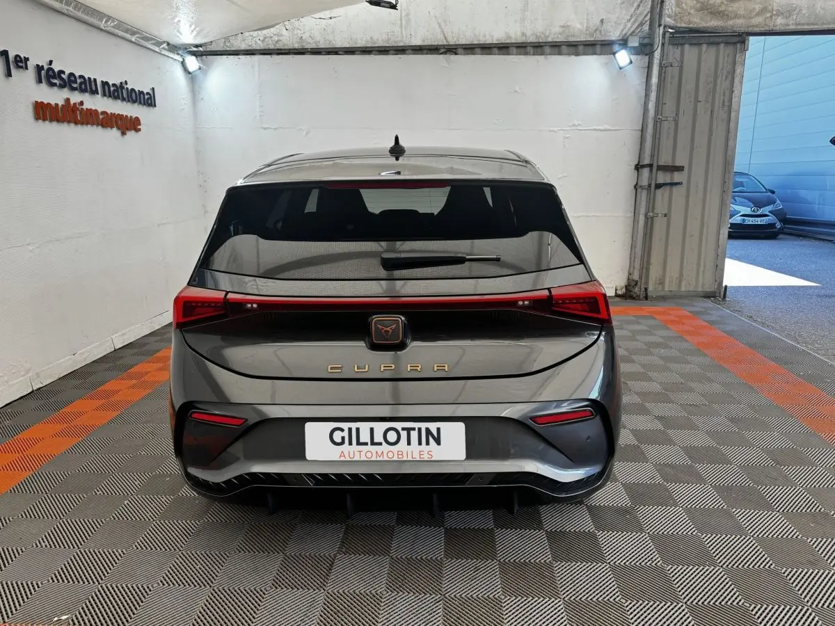 Vue arrière d'une CUPRA BORN gris foncé 2023 avec feux LED reliés et logo CUPRA lumineux au centre.
