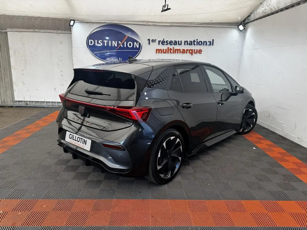 Vue 3/4 arrière droite d'une CUPRA BORN gris foncé avec jantes noires et feux arrière LED distinctifs.