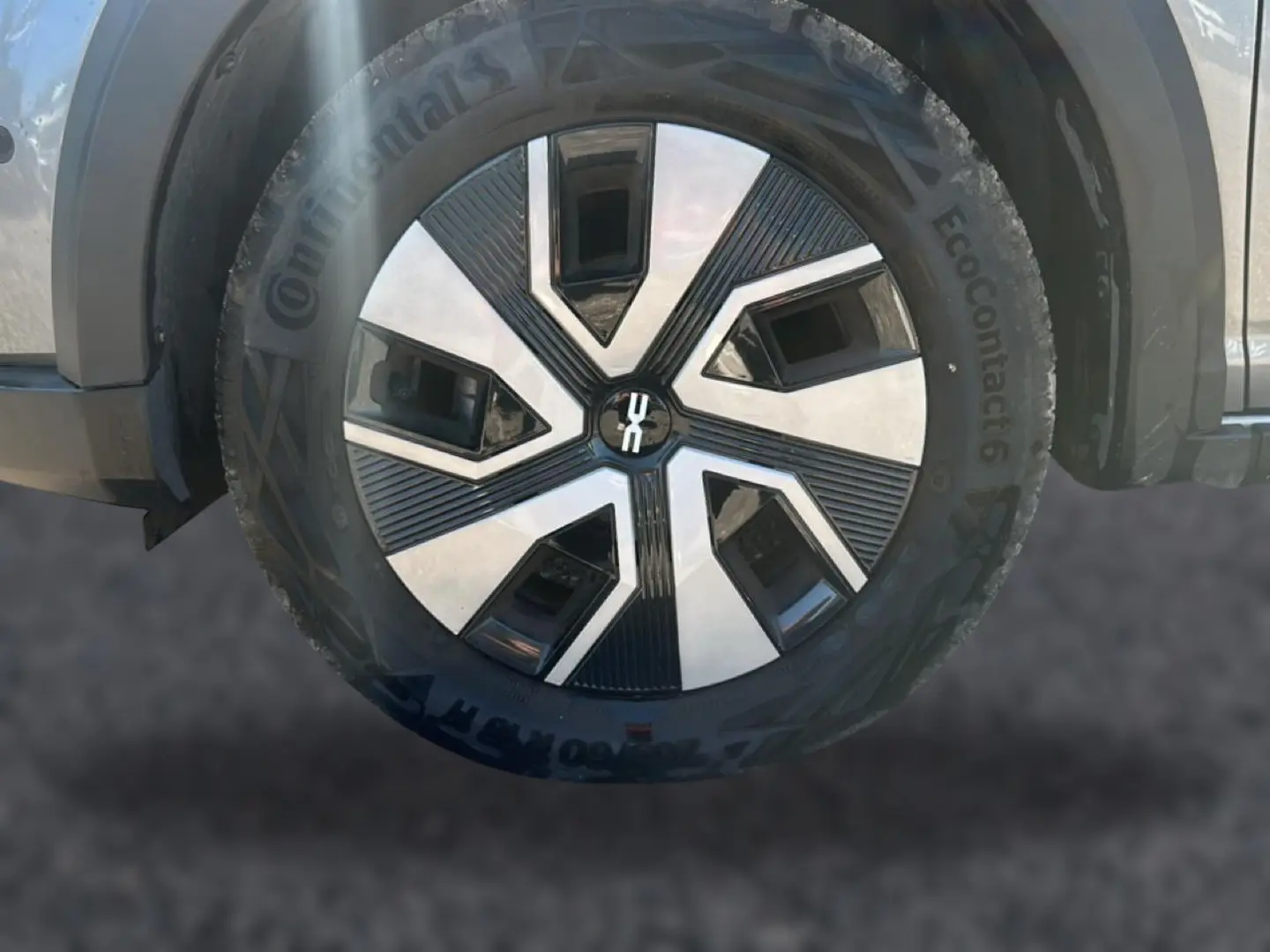 Gros plan sur la roue avant droite d'une Dacia Sandero gris schiste avec jante en alliage au design moderne.