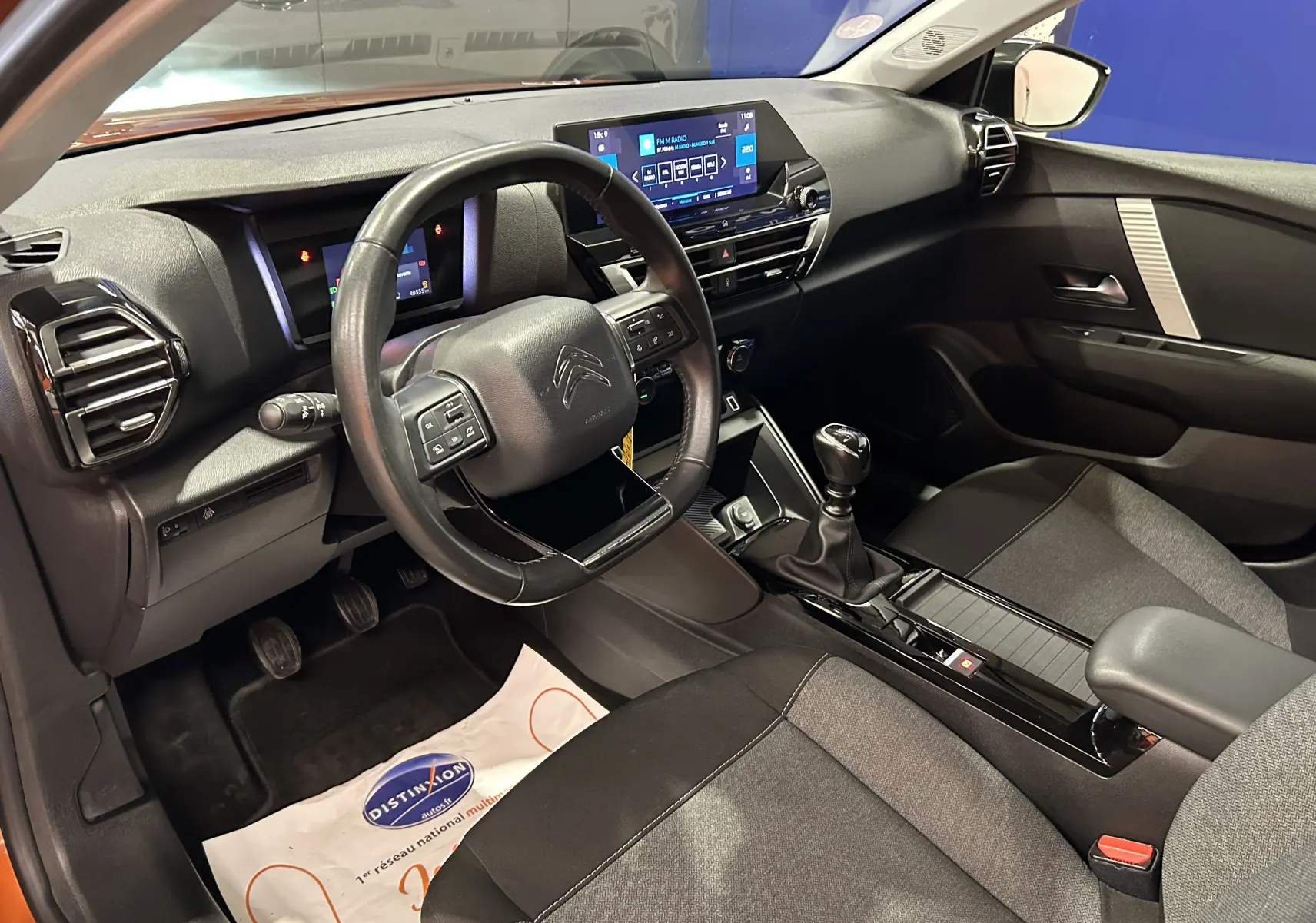 Intérieur de la Citroën C4 PureTech 100 Feel 2021, vue côté conducteur, tableau de bord et console centrale noirs.