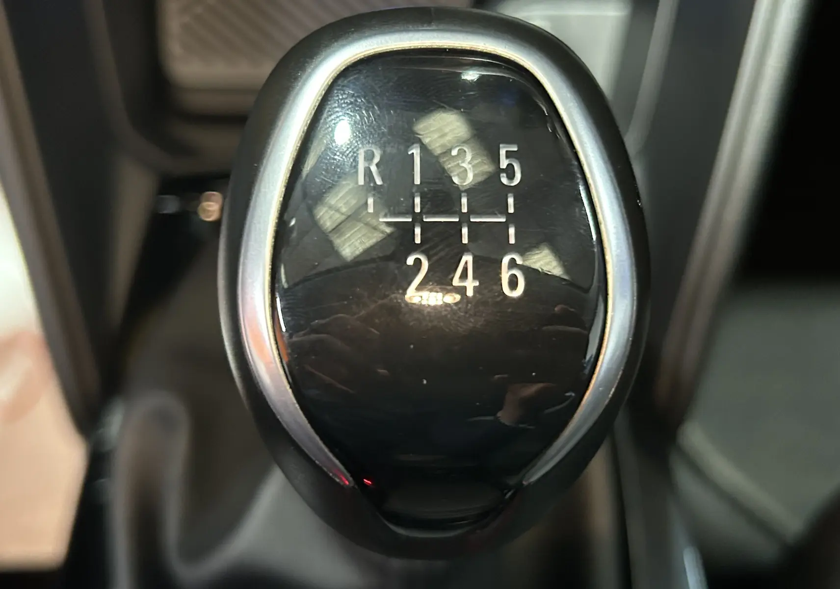 Gros plan sur le levier de vitesse manuel noir de la Citroën C4 PureTech 100 Feel 2021, avec marquage des six rapports et marche arrière.