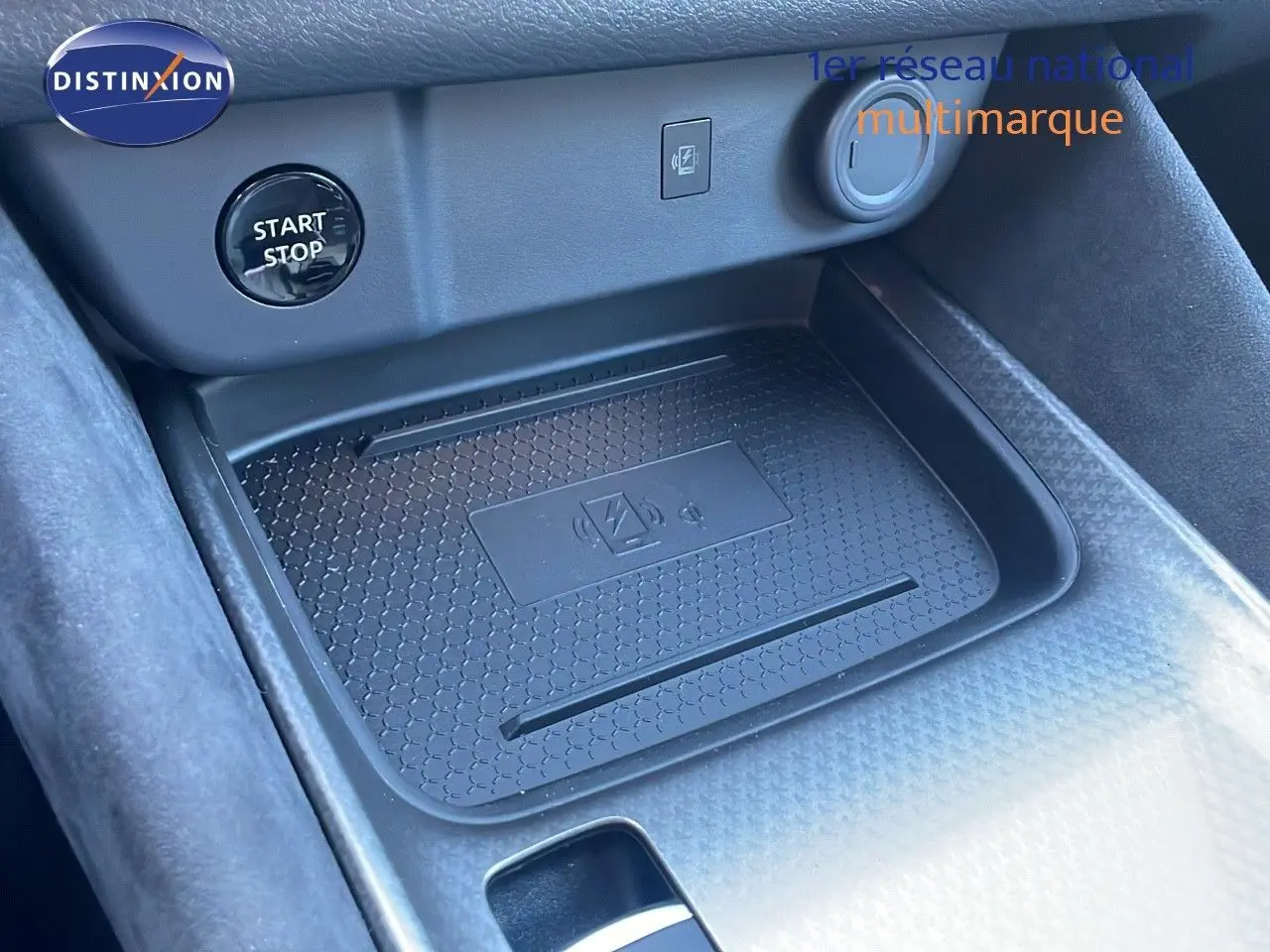 Détail du chargeur sans fil et bouton start/stop dans l'habitacle du Nissan Qashqai 2025 gris céramique.