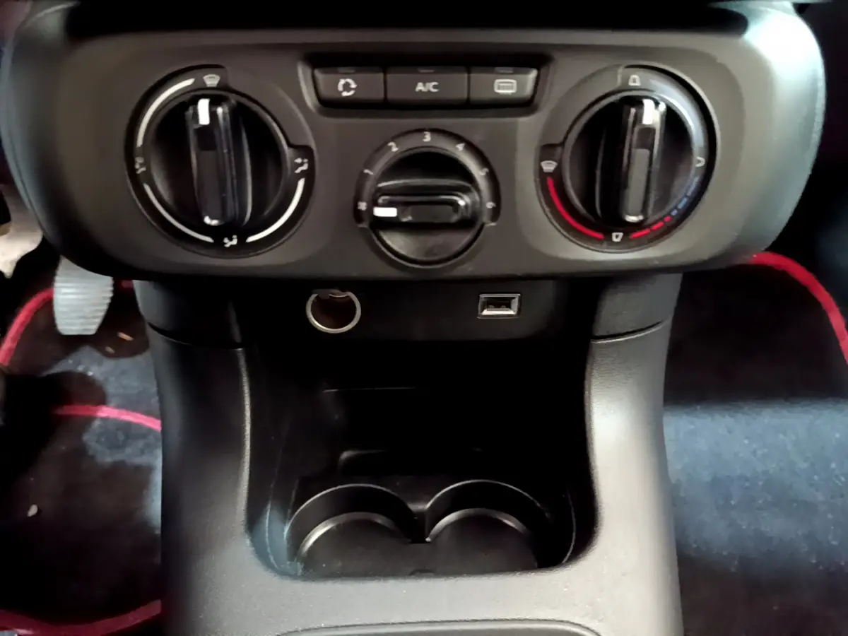 Vue rapprochée de la console centrale noire avec commandes de climatisation et prise USB de la Citroën C3 blanche 2018.