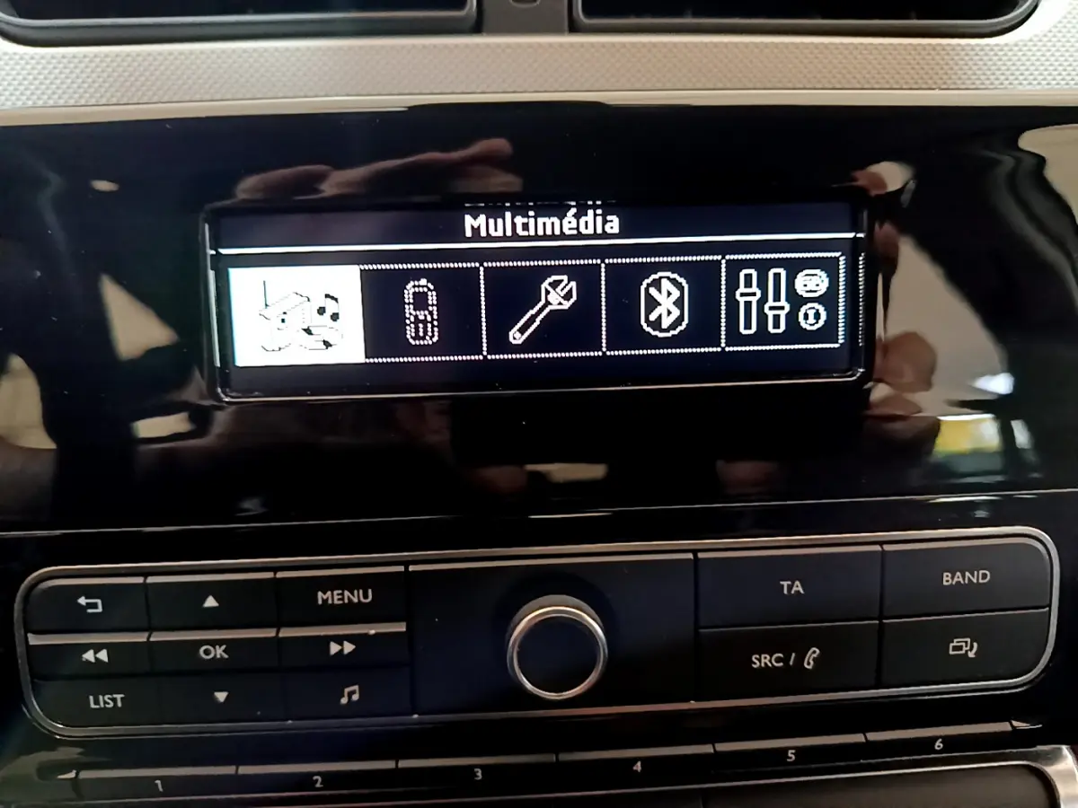 Écran multimédia et commandes centrales en gros plan dans l'habitacle noir brillant d'une Citroën C3 blanche PureTech 2018.