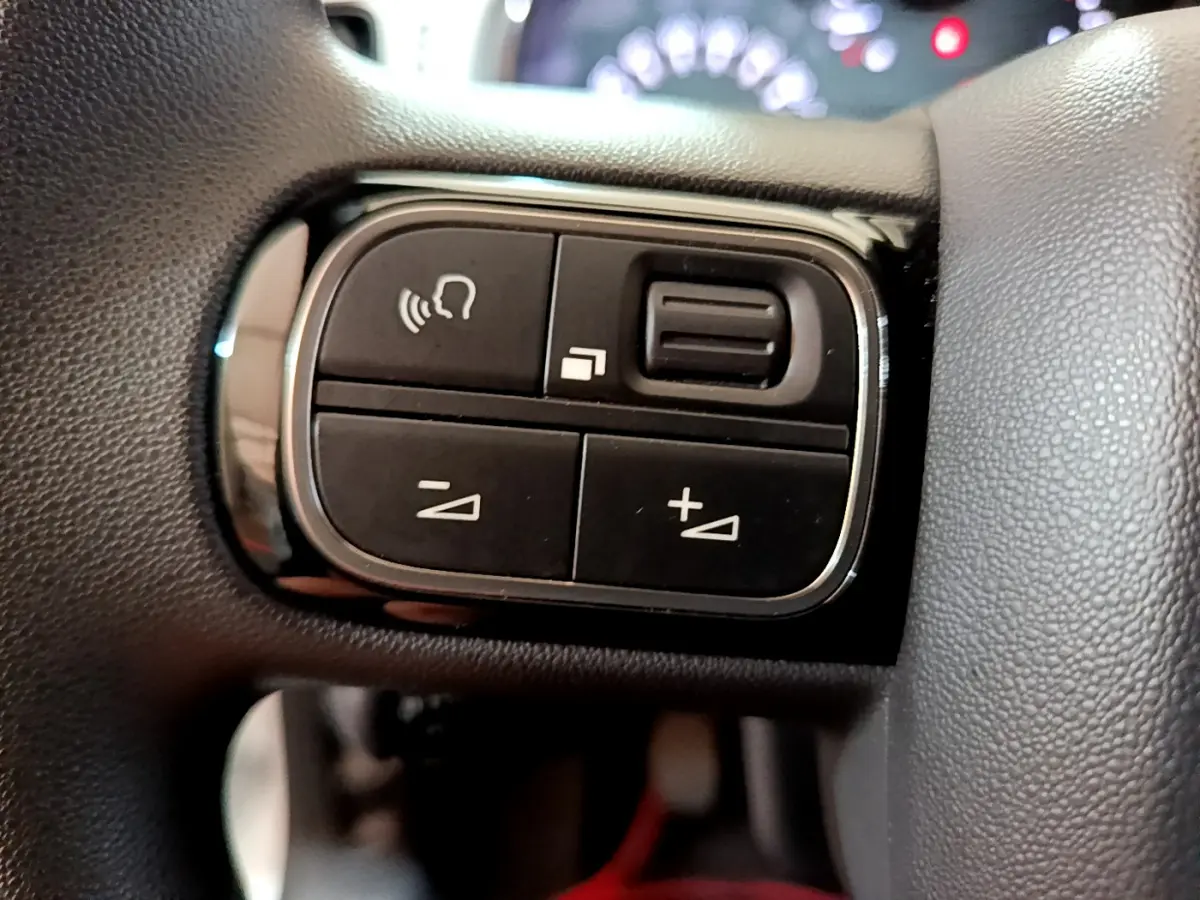 Gros plan sur les commandes noires du volant de la Citroën C3 blanche PureTech 68 BVM Live de 2018.