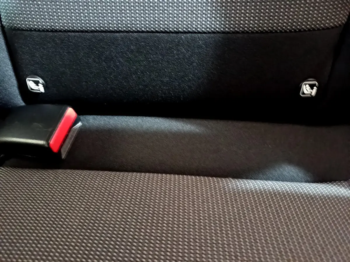 Gros plan sur la banquette arrière noire de la Citroën C3 avec attaches Isofix visibles et boucle de ceinture rouge.