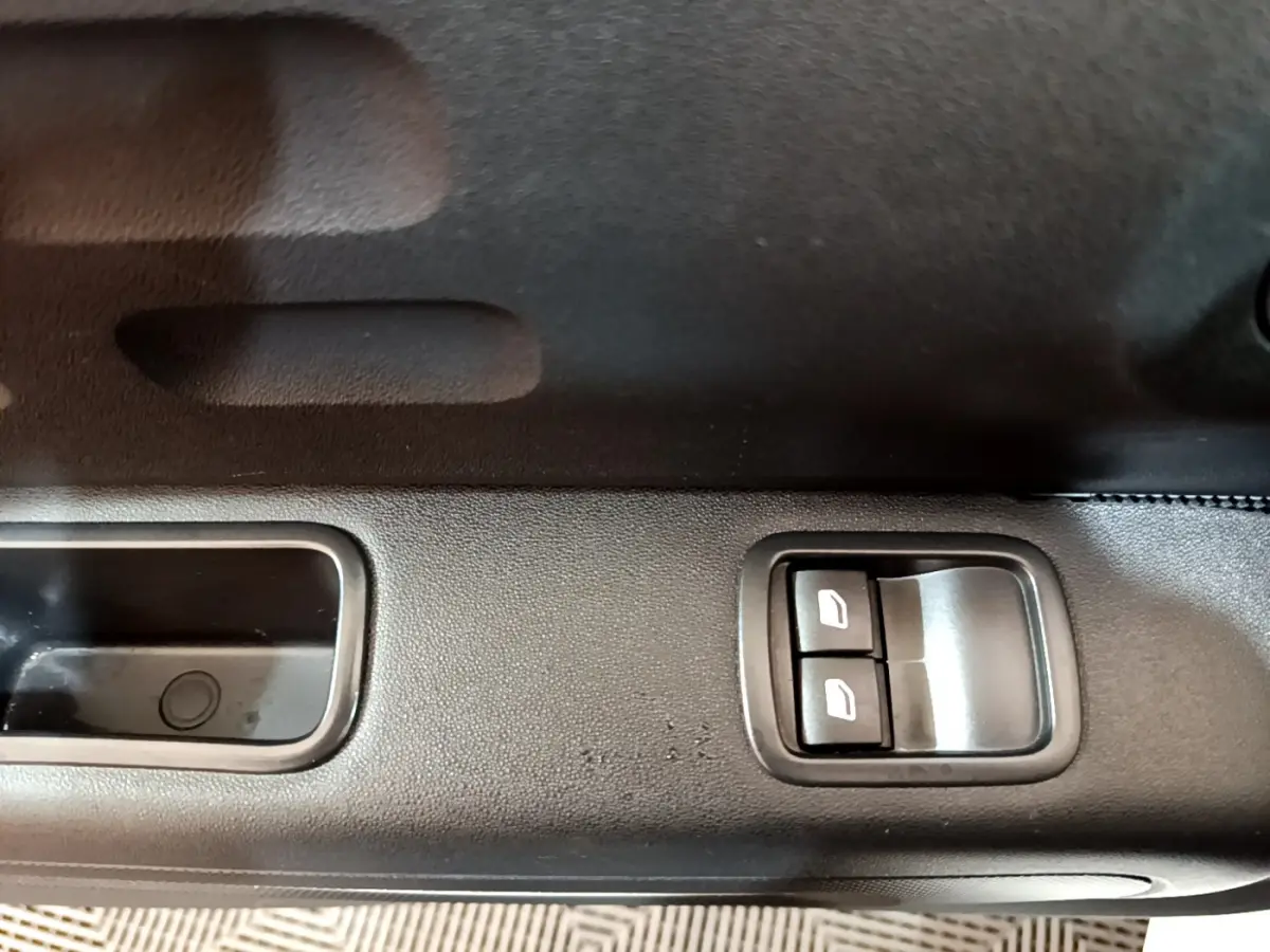 Gros plan sur les commandes de lève-vitres côté conducteur d'une Citroën C3 blanche PureTech 2018.