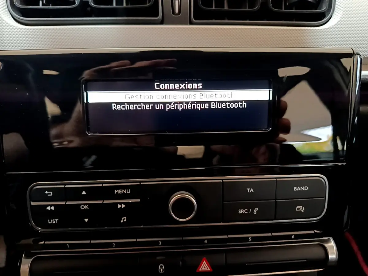 Détail de la console centrale noire de la Citroën C3 blanche 2018, affichant le menu Bluetooth sur l'écran.