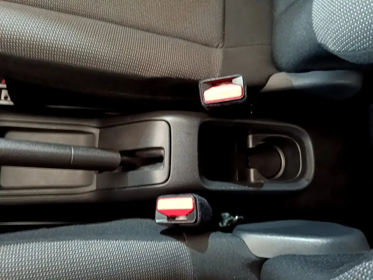 Vue plongeante sur la console centrale noire de la Citroën C3 2018, montrant frein à main et ceintures de sécurité rouges.