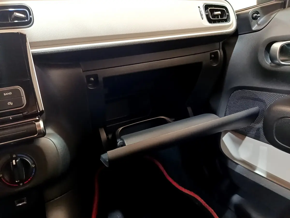 Intérieur de la Citroën C3 PureTech 68 BVM Live 2018, vue côté passager avec boîte à gants ouverte et tableau de bord noir et blanc.