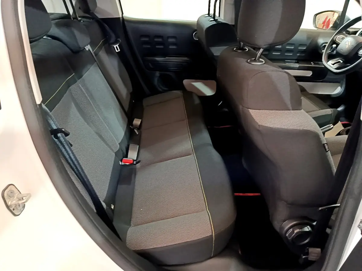 Vue intérieure côté gauche de la banquette arrière et sièges avant noirs d'une Citroën C3 blanche 2018.