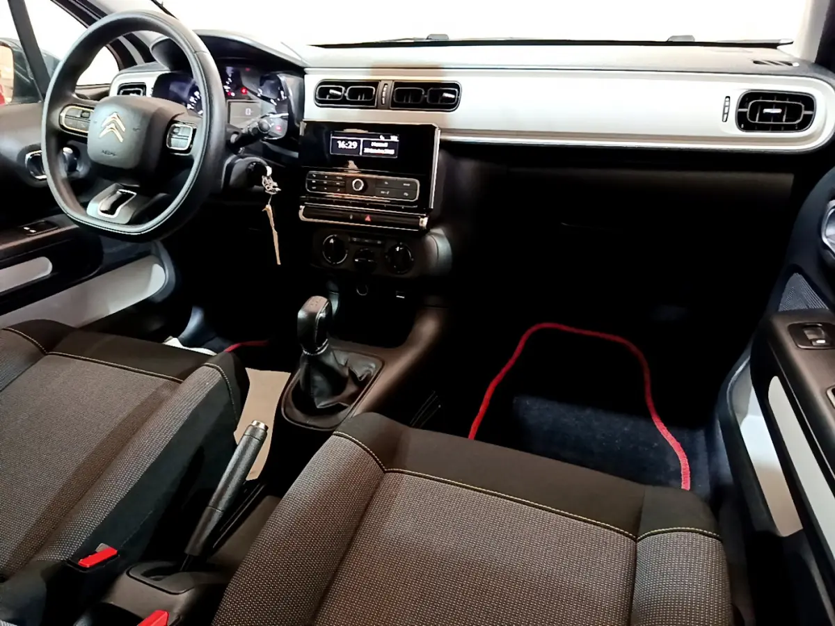 Intérieur avant droit de la Citroën C3 PureTech 68 BVM Live 2018 avec tableau de bord blanc et volant multifonction.