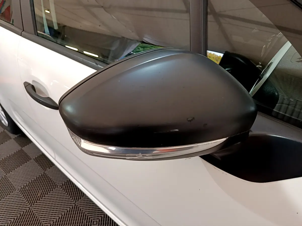 Gros plan sur le rétroviseur noir avec clignotant intégré côté gauche d'une Citroën C3 blanche de 2018.