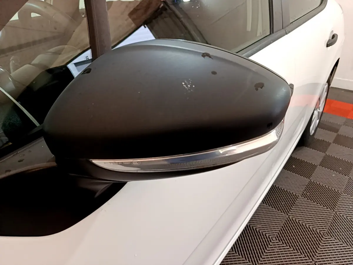 Gros plan sur le rétroviseur noir côté gauche de la Citroën C3 blanche PureTech 68 BVM Live de 2018.