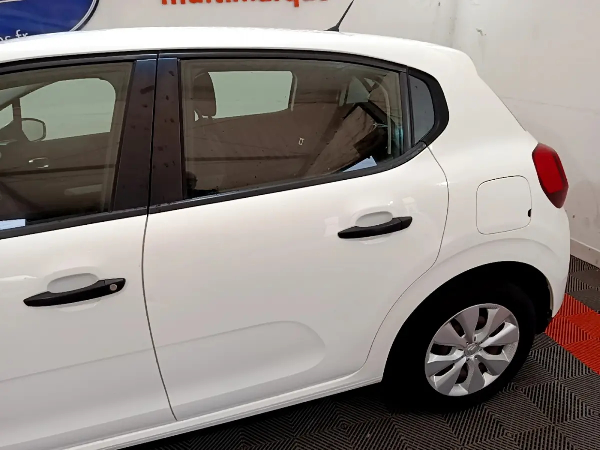 Vue latérale droite d'une Citroën C3 blanche de 2018 avec poignées noires et jantes compactes visibles.