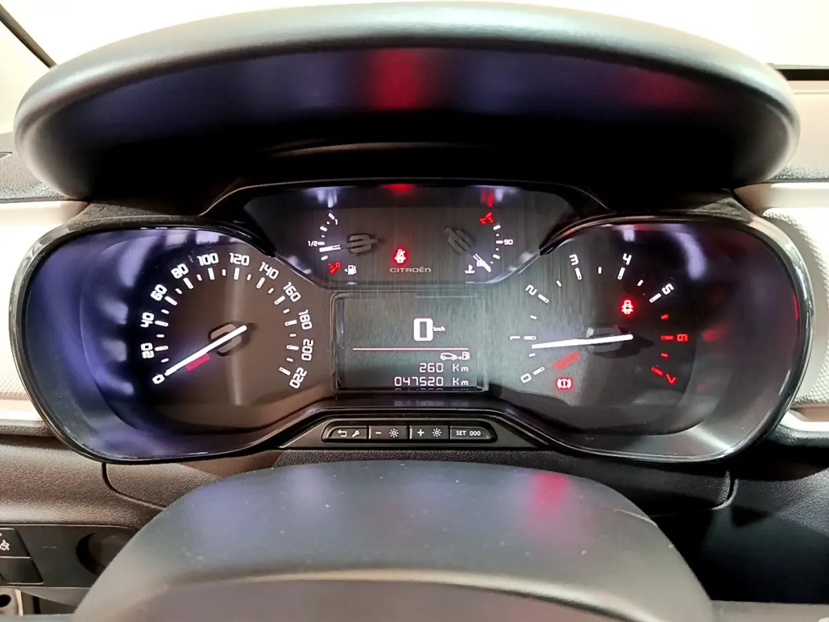 Vue rapprochée du tableau de bord de la Citroën C3 PureTech 68 BVM Live, affichant le compteur et les voyants allumés.