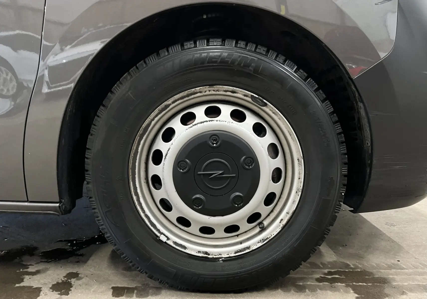 Gros plan sur la roue arrière droite grise d’un Opel Vivaro XL 2023 avec jante acier et logo Opel central.