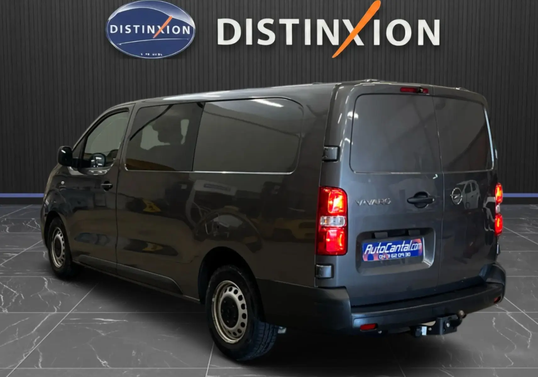 Vue 3/4 arrière droite d’un Opel Vivaro cabine approfondie gris 2023 avec vitres teintées et attelage visible.