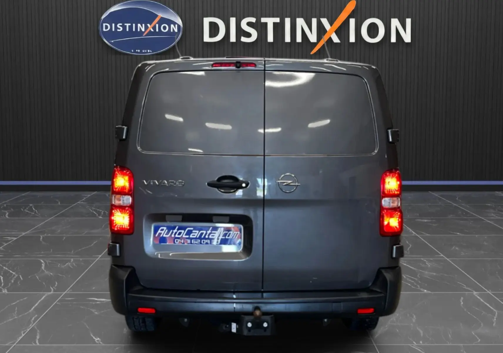 Vue arrière d’un Opel Vivaro cabine approfondie gris 2023 avec portes battantes fermées et feux allumés.