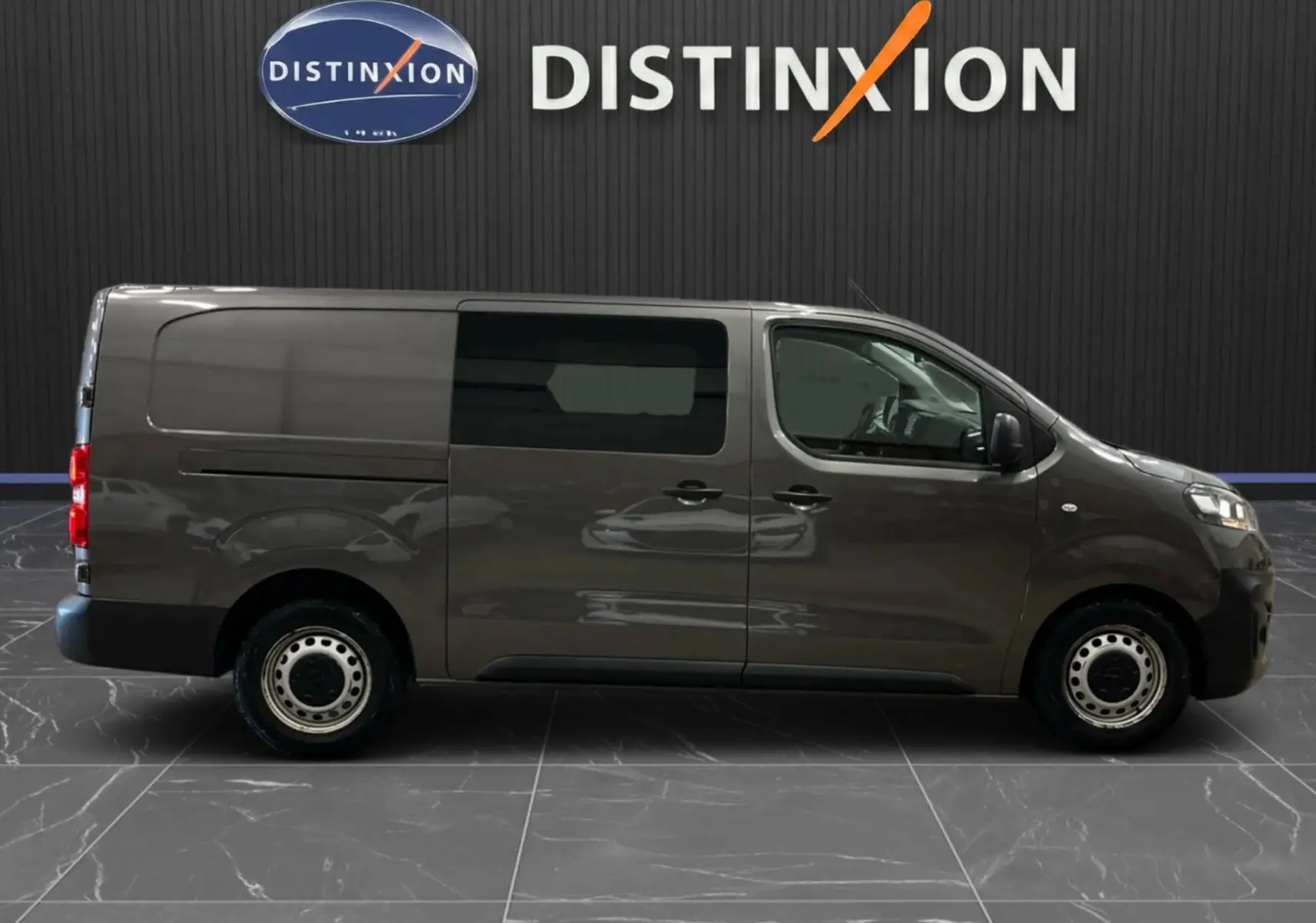 Vue de profil côté droit d’un Opel Vivaro Cabine Approfondie gris 2023 avec vitres teintées et jantes acier.