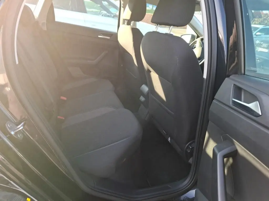 Vue intérieure côté gauche sur la banquette arrière noire d'une Volkswagen Polo 1.0 TSI 95 DSG7 Life 2022 avec porte ouverte.