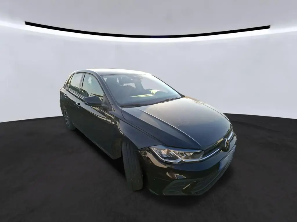 Volkswagen Polo 1.0 TSI noire vue 3/4 avant droit, avec calandre chromée et feux LED distinctifs.