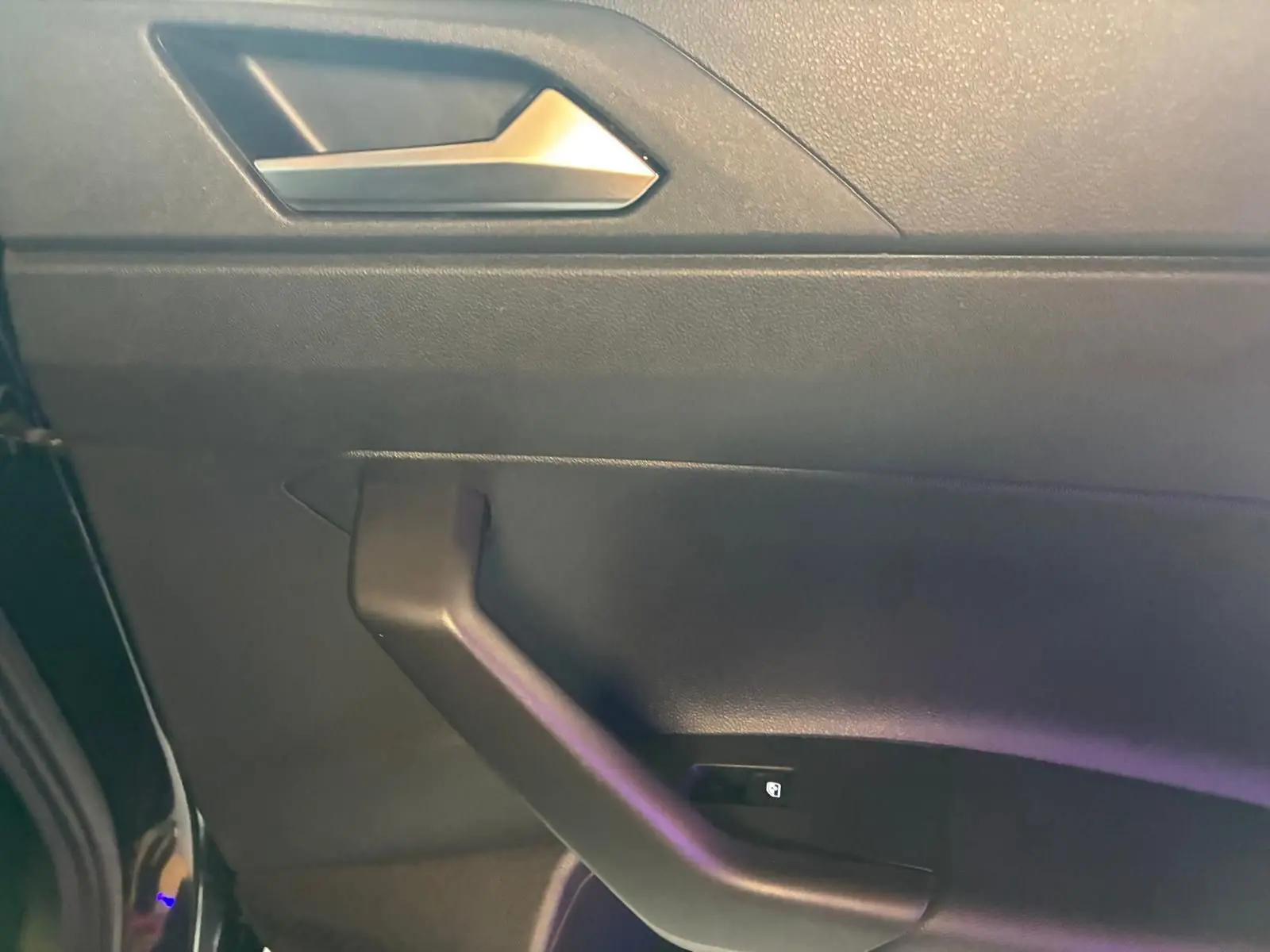 Détail de la porte avant gauche noire d'une Volkswagen Polo 2022 avec poignée et bouton de verrouillage intégré.