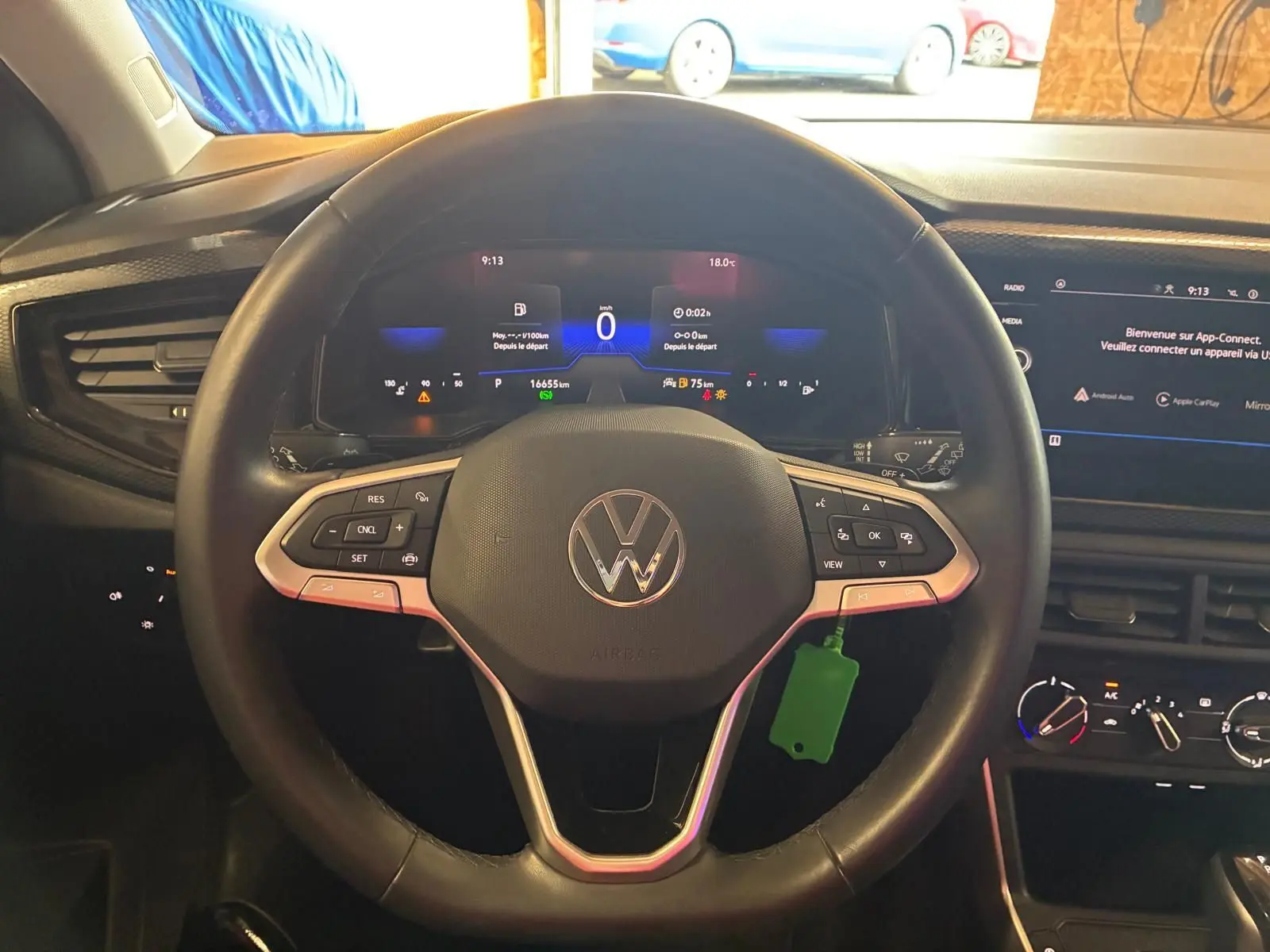 Vue intérieure centrée sur le volant noir multifonctions d'une Volkswagen Polo 2022 avec tableau de bord numérique allumé.