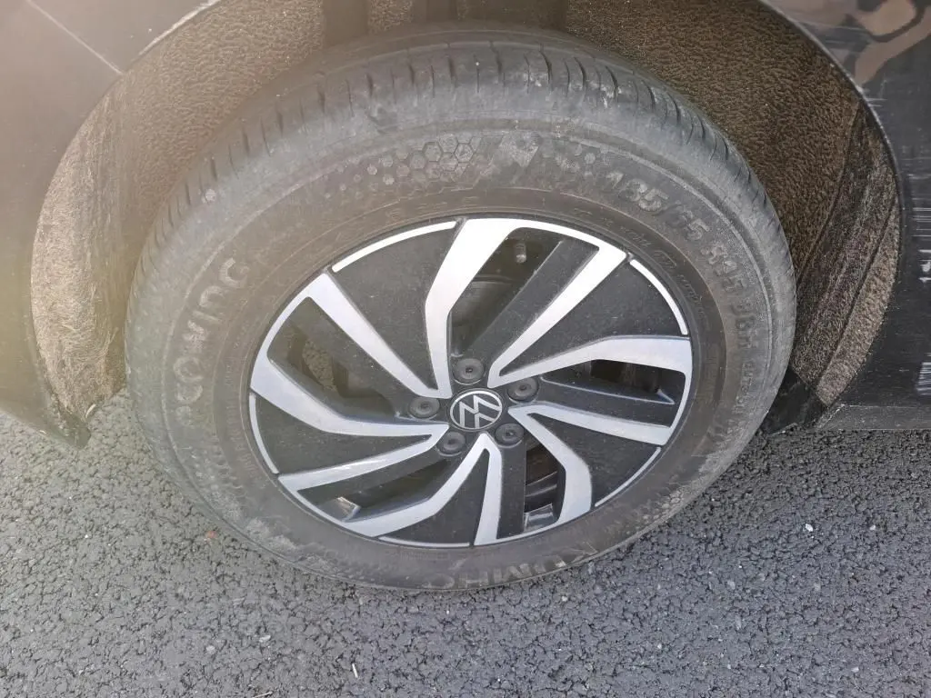 Gros plan sur la roue avant droite noire d'une Volkswagen Polo 1.0 TSI 95 DSG7 Life avec jante alliage bicolore.