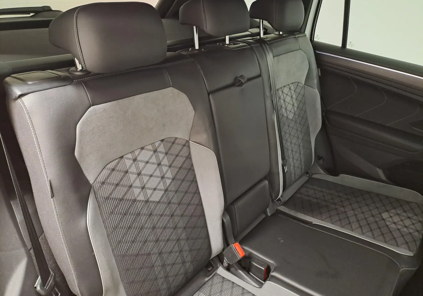 Vue intérieure des sièges arrière en cuir noir et tissu gris à motifs du Volkswagen Tiguan Allspace 2023.