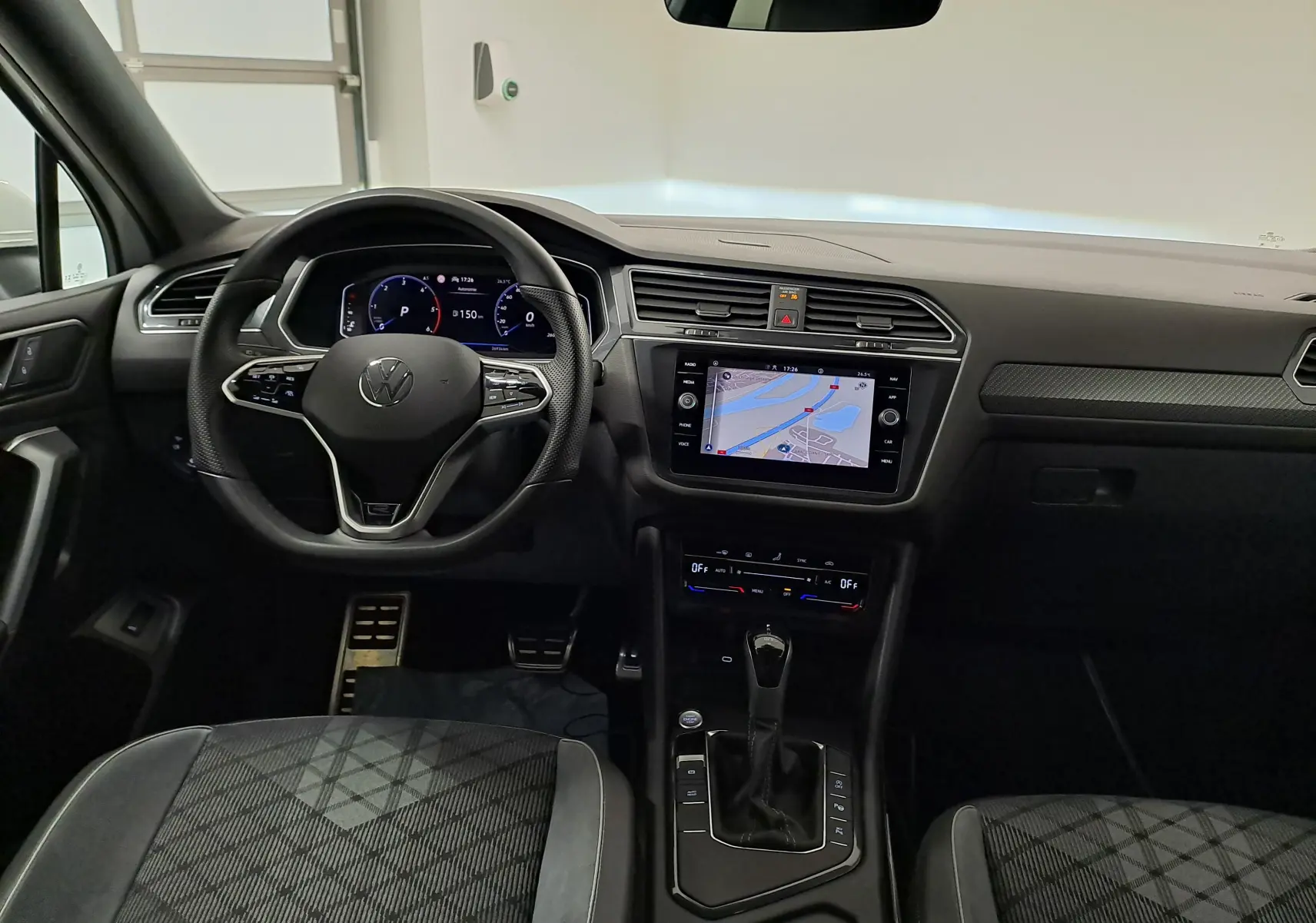 Vue intérieure du tableau de bord du Volkswagen Tiguan Allspace 2023, avec volant multifonction et écran tactile central.