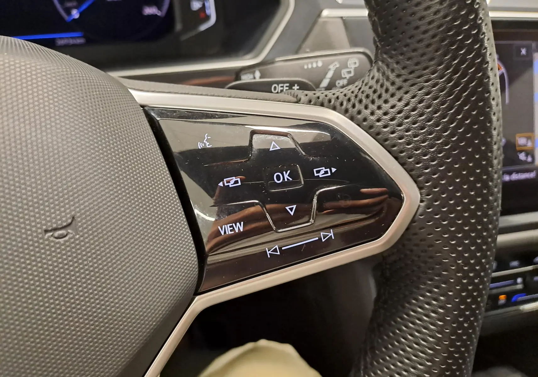 Gros plan sur les commandes du volant côté gauche du Volkswagen Tiguan Allspace blanc 2023 finition R-Line.