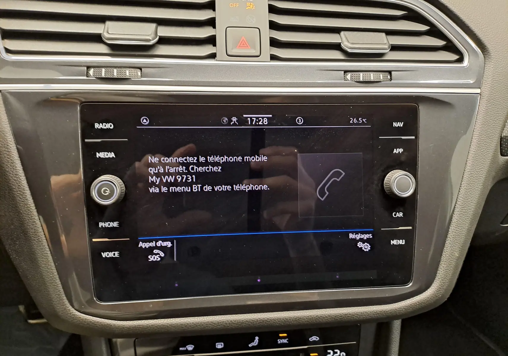 Vue rapprochée de l’écran tactile central noir du Volkswagen Tiguan Allspace blanc, affichant le menu téléphone et commandes multimédia.
