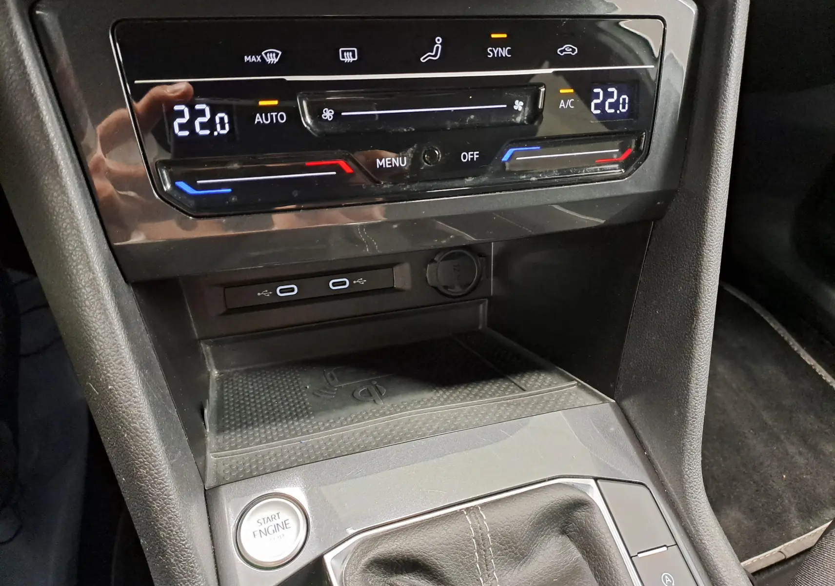 Détail de la console centrale du Volkswagen Tiguan Allspace 2023 blanc, avec commandes climatisation digitales et bouton start engine.