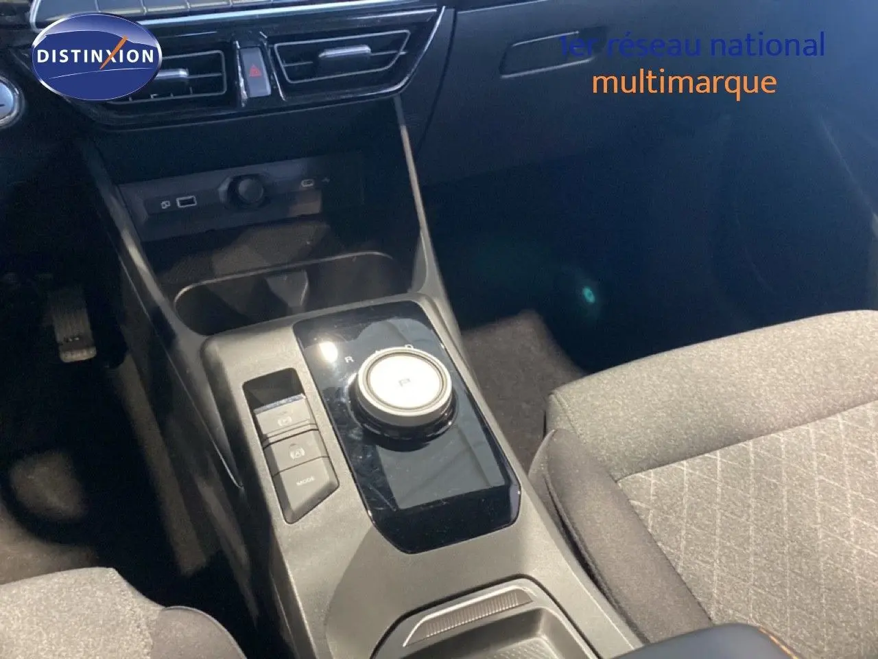 Vue rapprochée de la console centrale de la MG3 1.5 Hybrid 2024, avec boîte automatique et sellerie tissu gris.