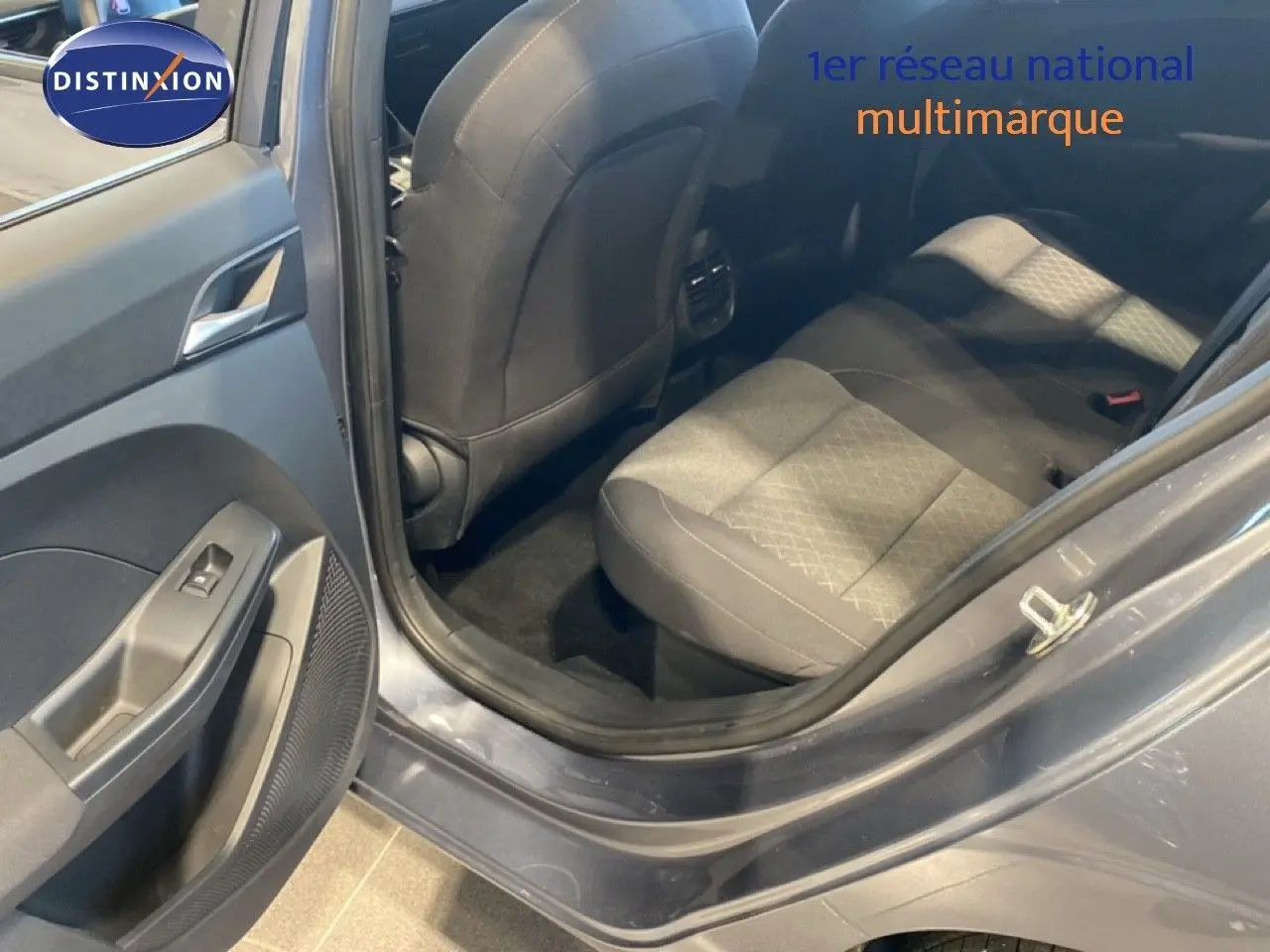 Vue intérieure côté arrière gauche de la MG3 1.5 Hybrid 195ch Comfort en gris Hampstead, montrant les sièges arrière et la portière ouverte.