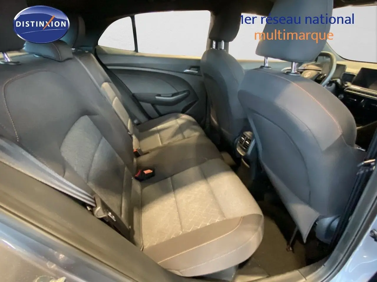 Vue intérieure arrière côté gauche du MG3 1.5 Hybrid 2024 en tissu gris avec surpiqûres orange et sellerie bi-matière.