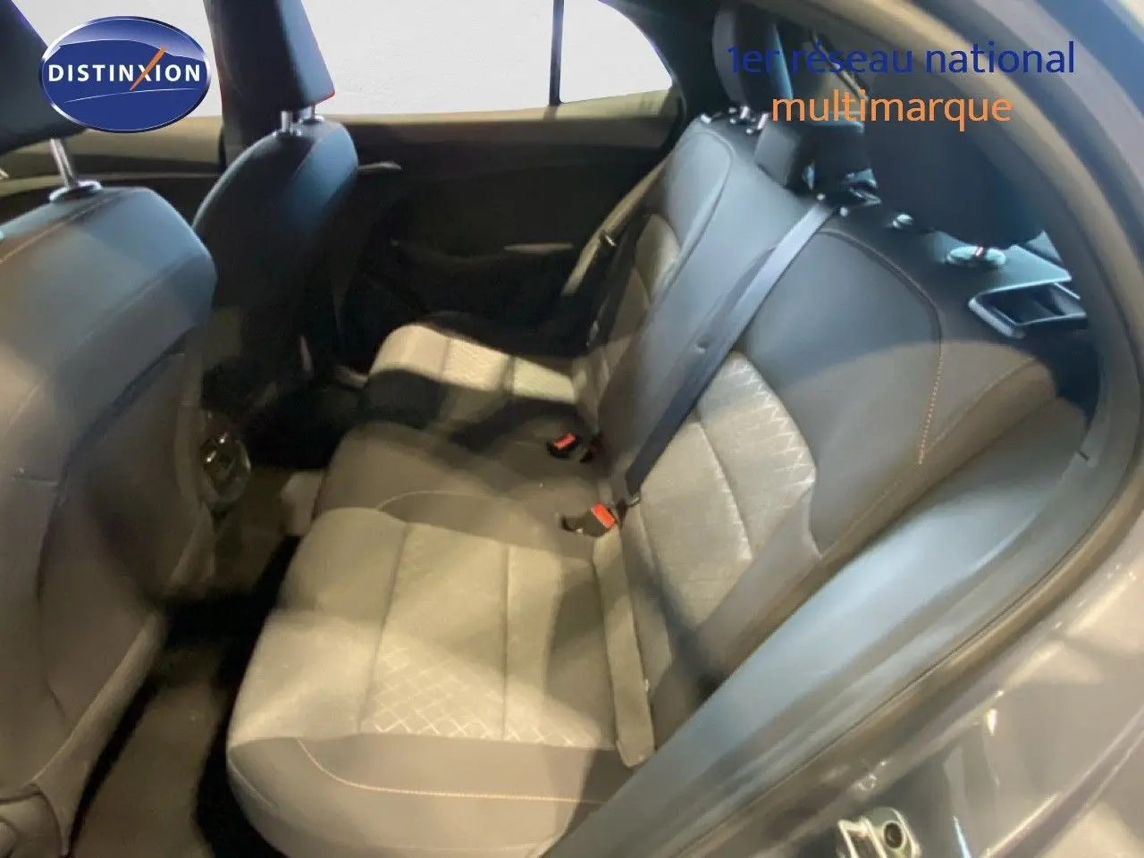 Vue intérieure arrière des sièges en tissu gris noir de la MG3 1.5 Hybrid 2024, avec ceinture de sécurité et porte ouverte.