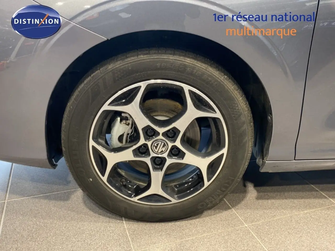 Gros plan sur la roue avant gauche de la MG3 1.5 Hybrid 195ch Comfort en gris Hampstead, avec jante alliage bicolore.