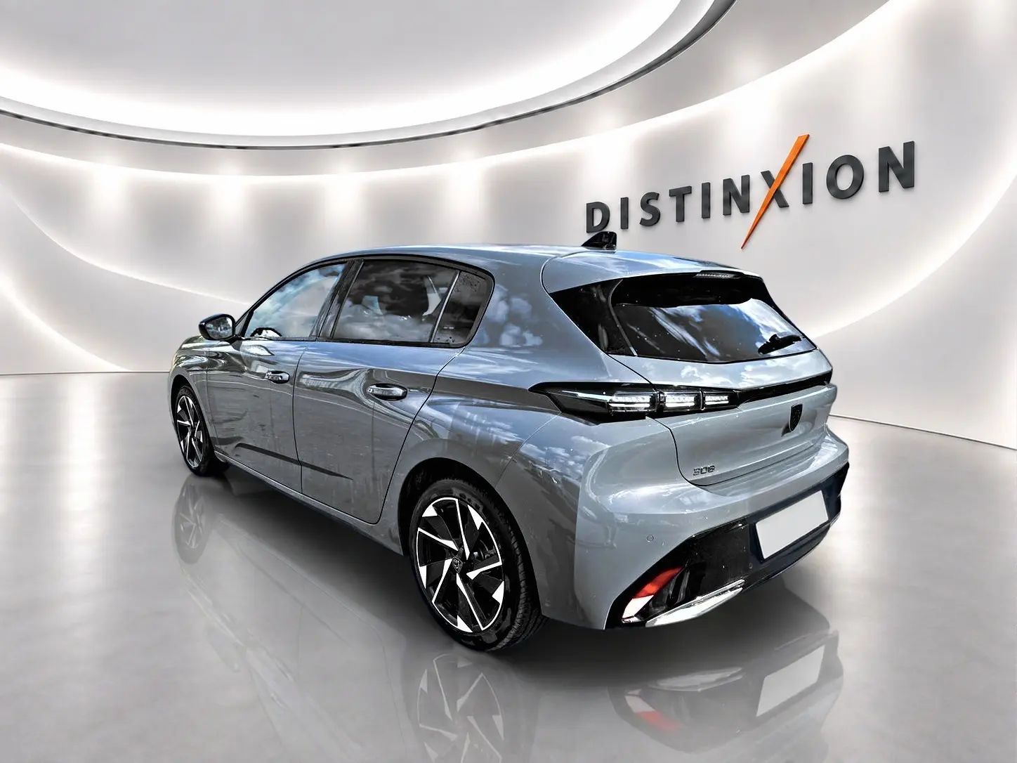 Peugeot 308 gris vue 3/4 arrière droit dans un showroom avec jantes alliage et feux LED distinctifs.