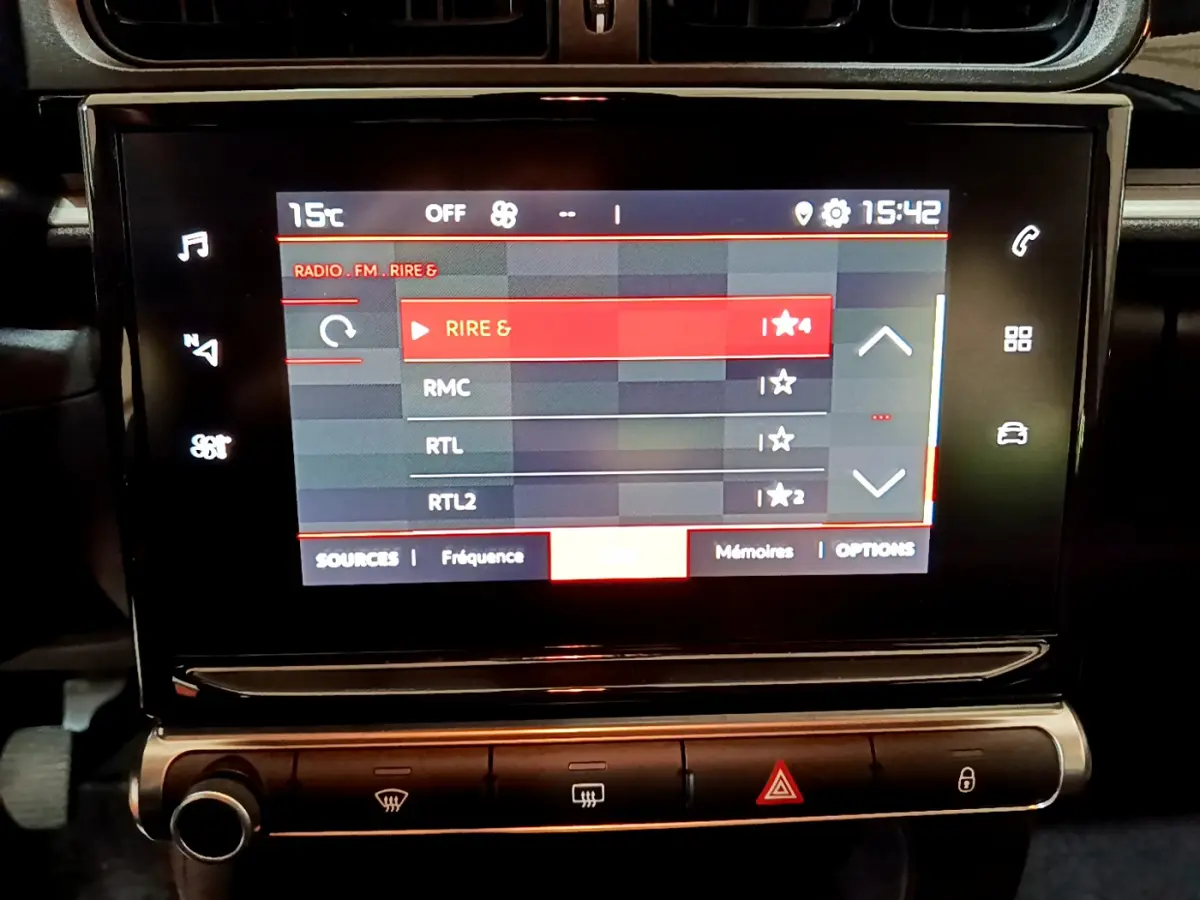 Écran tactile central affichant les stations radio dans l'habitacle d'une Citroën C3 beige de 2022.