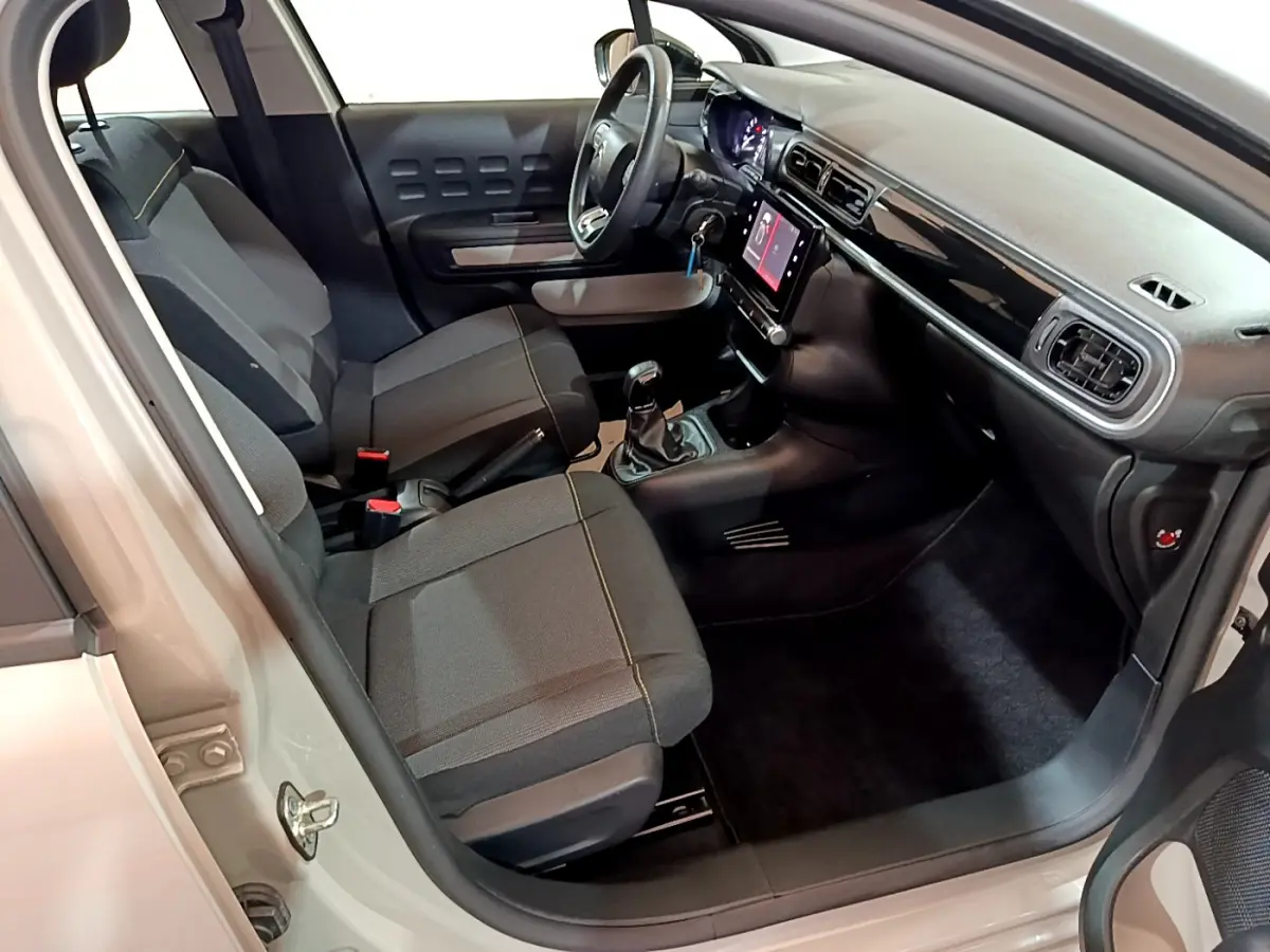Intérieur avant de la Citroën C3 beige 2022, vue côté conducteur, avec tableau de bord noir et écran tactile central.